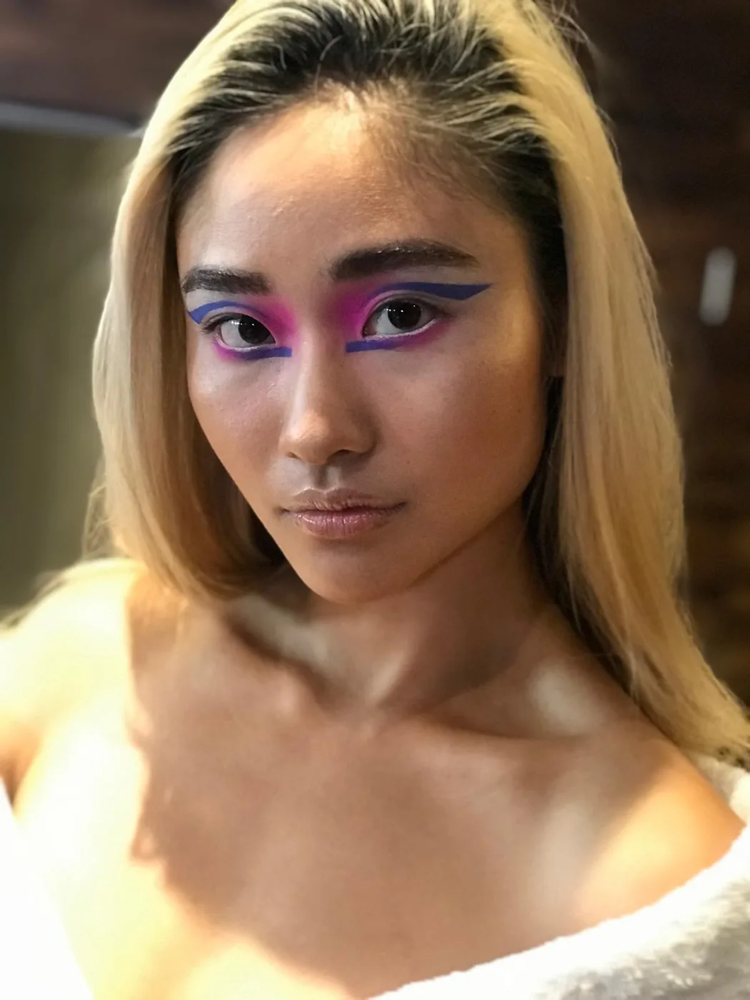 Machiaj grafic în mov și roz pe pleoapă, look finalizat înainte de podium, London Fashion Week